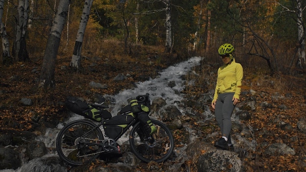 Die Frau reist auf gemischtem Gelände Radtouren mit Bikepacking Die Reise des Reisenden mit Fahrradtaschen Sporttourismus Bikepacking