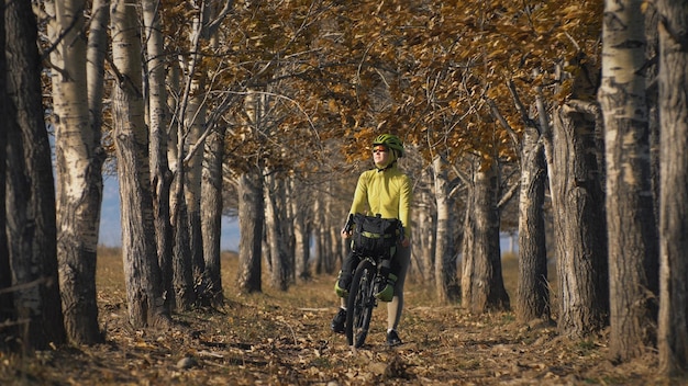 Die Frau reist auf gemischtem Gelände Radtouren mit Bikepacking Die Reise des Reisenden mit Fahrradtaschen Sporttourismus Bikepacking