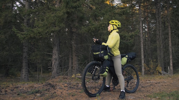 Die Frau reist auf gemischtem Gelände Radtouren mit Fahrrad Bikepacking im Freien Die Reise des Reisenden