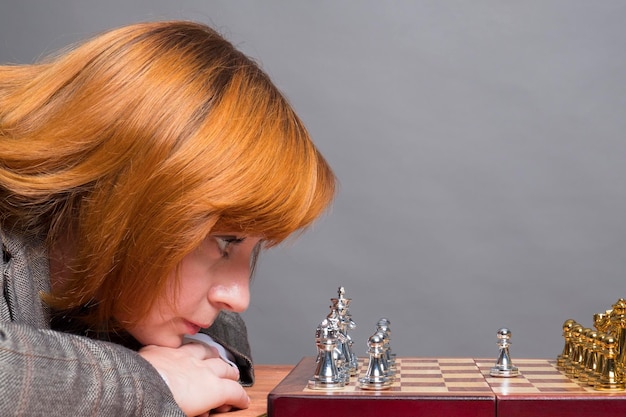 Foto die frau spielt schach schachbrett und figuren auf dem tisch