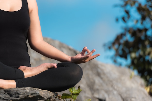 Die Frauen spielen Yoga-Pose auf Steinboden