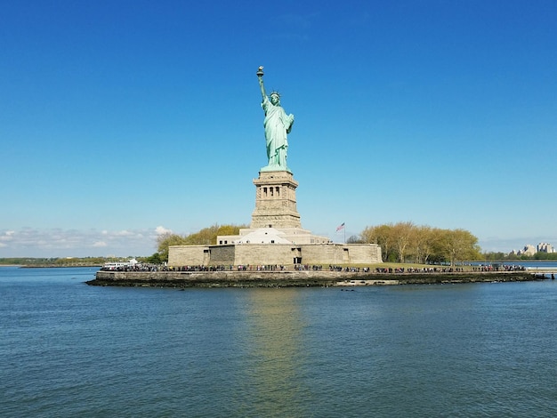 Die Freiheitsstatue und das Meer gegen den klaren blauen Himmel an einem sonnigen Tag