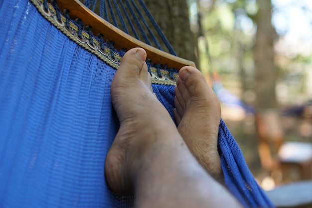 Die Füße des Mannes liegen im Urlaub auf dem Bett