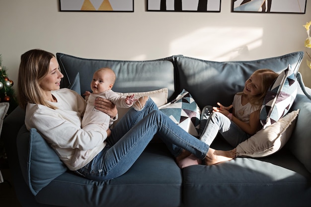 Die ganze Länge der Mutter sitzt auf dem Sofa-Bett