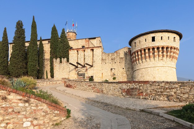 Die gepflasterte Straße führt über die Zugbrücke Ponte Levatoio zum Turm der Gefangenen, Brescia, Lombardei, Italien