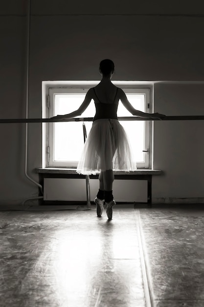 Foto die gesamte länge der jungen balletttänzerin, die auf dem boden tanzt