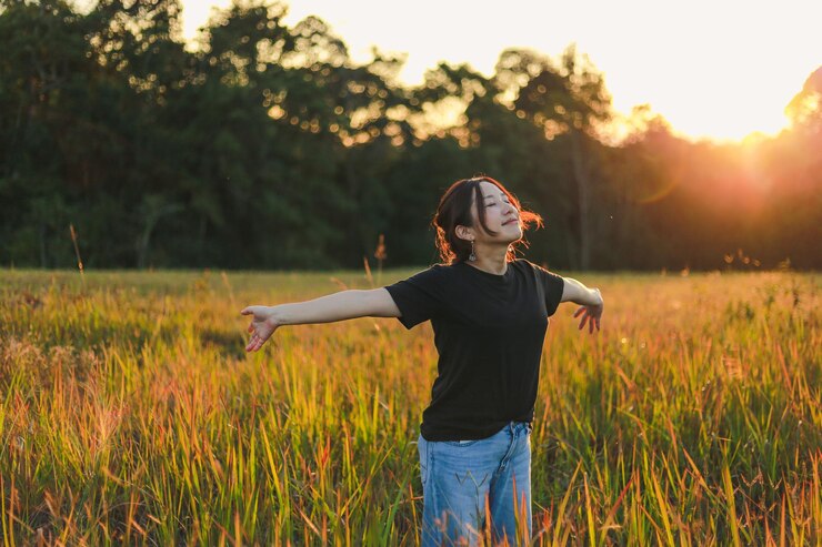 Foto die gesamte länge einer jungen frau, die auf dem feld steht