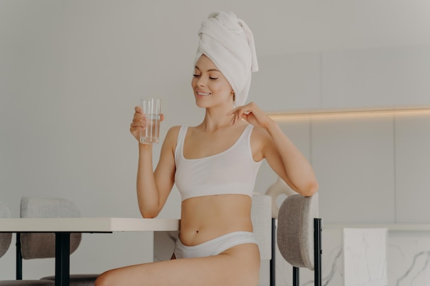 Foto die gesamte länge einer jungen frau, die ein glas trinkt