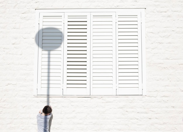 Foto die gesamte länge einer person, die an einer weißen wand steht