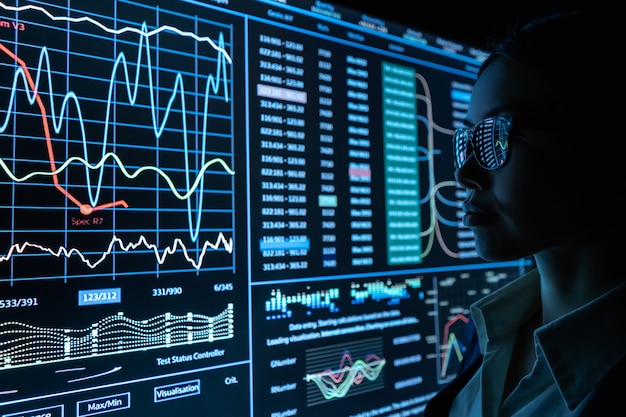 Die Geschäftsfrau arbeitet mit Infografik auf einem schwarzen Monitor