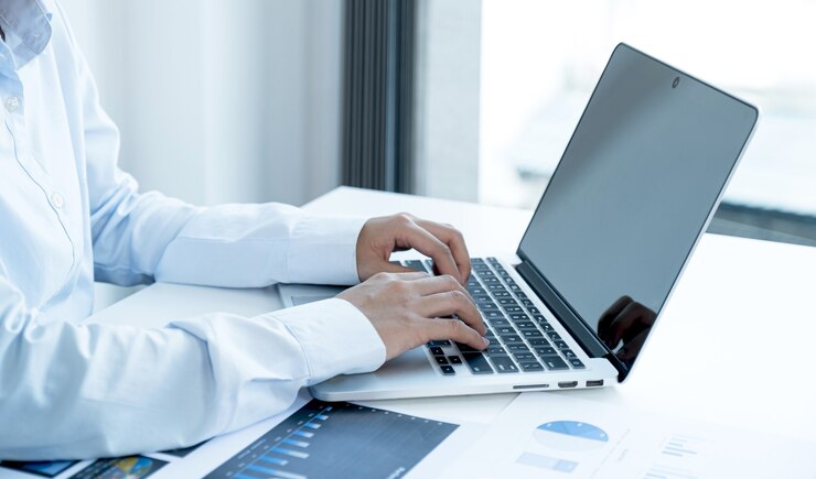 Die Geschäftsfrau gibt die Tastatur ein und analysiert das Diagramm mit dem Laptop im Home Office, um herausfordernde Geschäftsziele festzulegen und das neue Ziel zu erreichen.