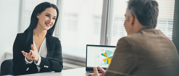 Die Geschäftsfrau und ein Mann unterhalten sich am Bürotisch