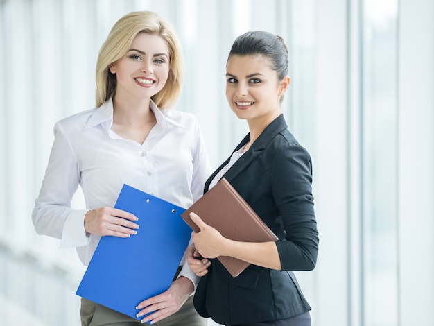 Die Geschäftsfrauen, die formal gekleidet werden, besprechen Projekt im Büro.