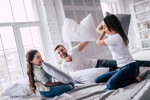 Die glückliche Familie Kissenschlacht auf dem Bett