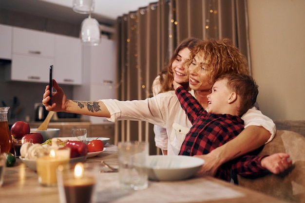 Die glückliche Familie von Mutter, Tochter und Sohn ist abends in der Küche