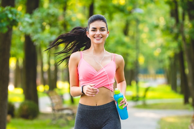 Die glückliche Sportlerin, die im Park läuft