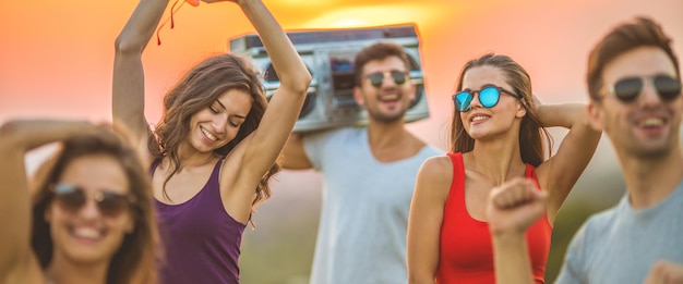 Foto die glücklichen freunde tanzen auf dem sonnenaufgangshintergrund