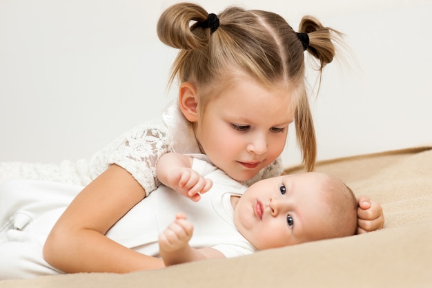 Foto die große schwester umarmt und spricht mit ihrem kleinen bruder mit liebe