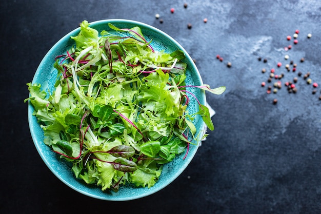 Die grüne Salatmischung hinterlässt Vitamine, die zum Kochen und Essen auf dem Tisch bereit sind, um eine gesunde Mahlzeit zuzubereiten