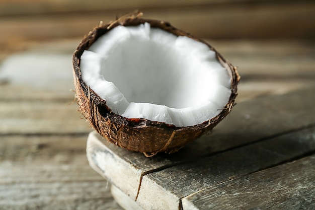 Die Hälfte der reifen Kokosnuss auf Holztisch