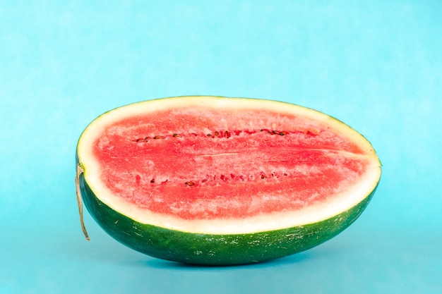 Die Hälfte der Süßwassermelone auf blauem Hintergrund. Frisches leckeres Sommerdessert. Stock Foto