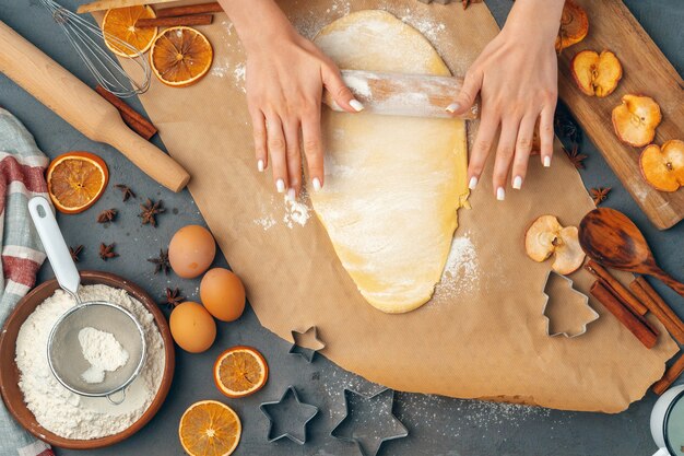 Die Hände der Frau, die oben Teig für Plätzchen zubereiten, schließen oben