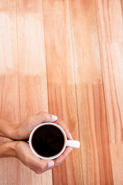 Die Hände der Frau, die Tasse Kaffee halten