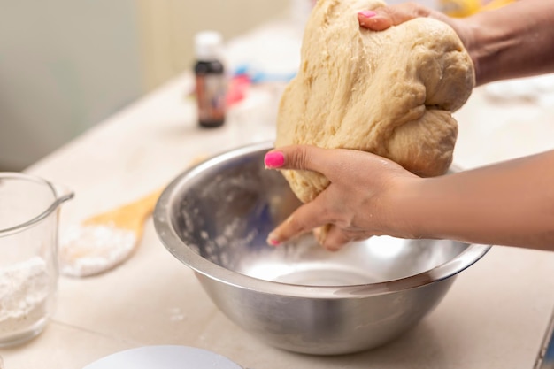 Die Hände der Frau kneten Zutaten, um Pan de Muerto zu machen