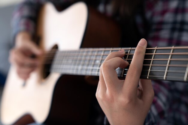 Die Hände der Frau spielen Akustikgitarre aus nächster Nähe