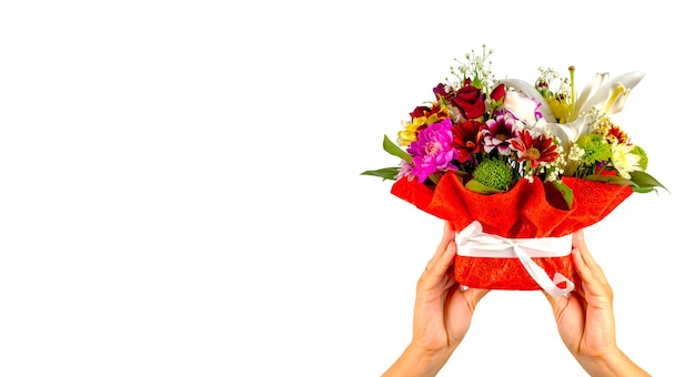 Die Hände der Frauen, die bunten Blumenstrauß halten Zusammensetzung der verschiedenen Blumen im Verpackungskorb auf lokalisiertem weißem Hintergrund