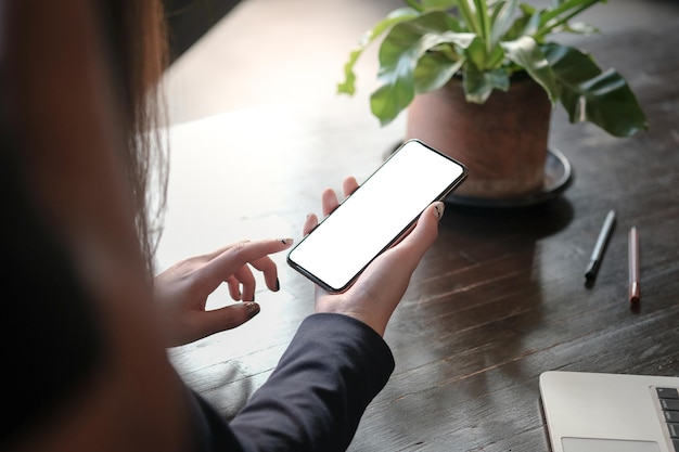 Die Hände der Frauen, die das Smartphone des leeren Kopienraumbildschirms des Mobiltelefons mit Technologiekonzept halten