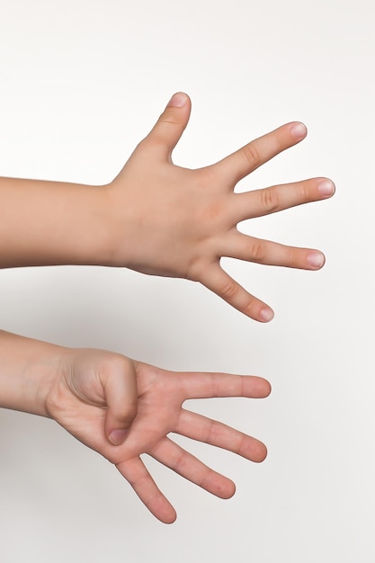 Die Hände der Kinderhände zeigen ein Herz auf einem weißen Hintergrund, isolierte Nahaufnahme