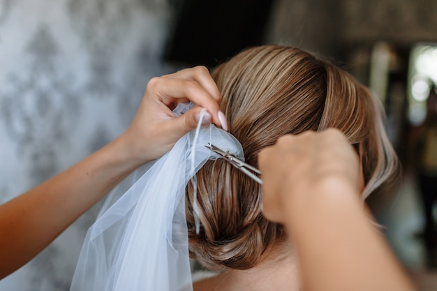 Die hände des mädchens schneiden den faden, der den hochzeitsschleier hält