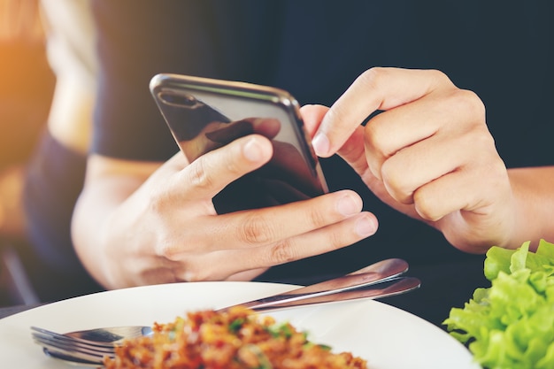 Die Hände des Mannes benutzen Zeigefinger Mobiles intelligentes Telefon