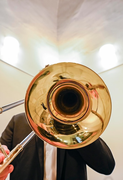 Die Hände des Mannes spielen die Posaune im Orchester