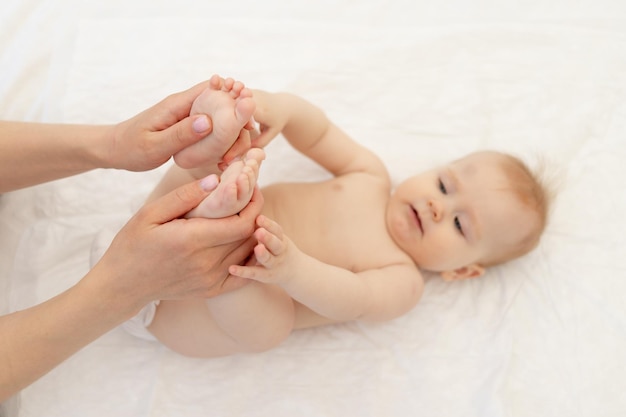 Die Hände des Masseurs oder der Mutter machen eine Fußmassage für das Baby, konzentrieren sich auf die Hände