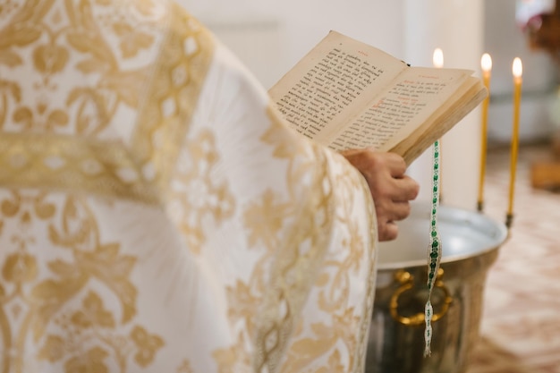 Die Hände des Priesters halten den selektiven Fokus der Bibeln der orthodoxen Kirche