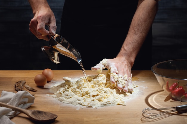 Die Hände kochen, den Teig kneten und dem Mehl Wasser hinzufügen