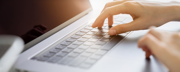 Die Hände tippen Tastatur auf Laptop mit online arbeiten.