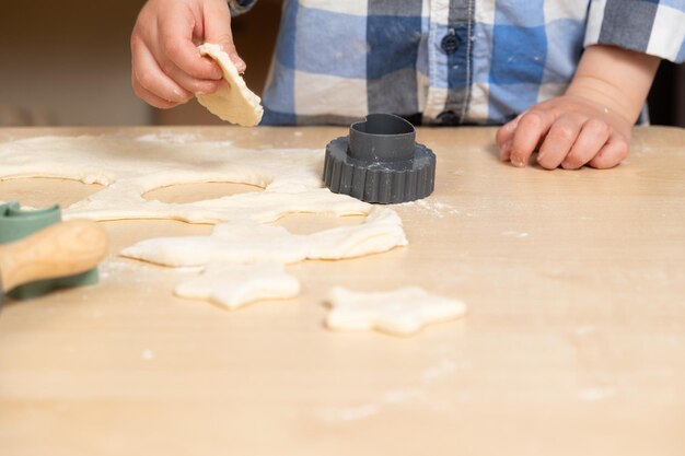 Foto die hände von childs machen teigkekse mit teigformen, platz für text