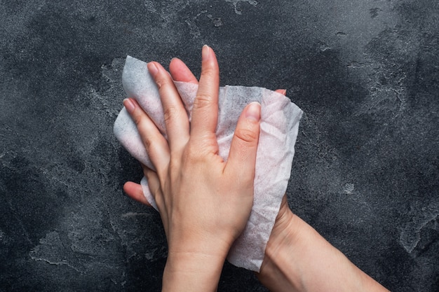 Die Hände werden mit einem feuchten antibakteriellen Tuch auf Beton abgewischt