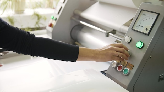 Die Hand der Frau an der arbeitenden Druckmaschinen-Polygrafenindustrie