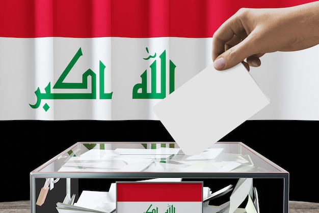 Die Hand der irakischen Flagge lässt die Stimmkarte in eine Kiste fallen, die Wahlen wählt