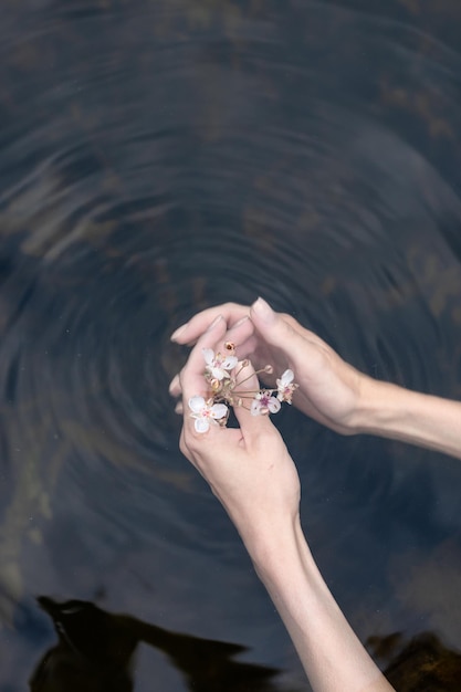 Die Hand der jungen Frau, die das Wasser im Meer berührt