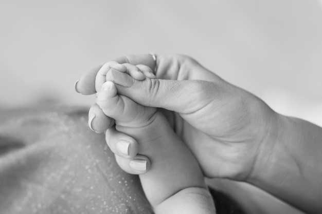 Die Hand der neugeborenen Kinder in der Mutterhand Mama und ihr Kind Happy Family Konzept