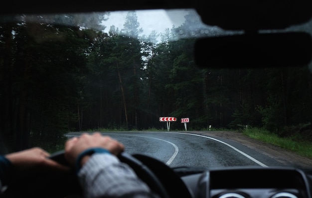 Die Hand des Fahrers auf einem Lenkrad in einem Auto auf einer Straße