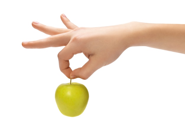 Die Hand des Jungen, die frischen grünen Apfel lokalisiert auf weißem Hintergrund hält.