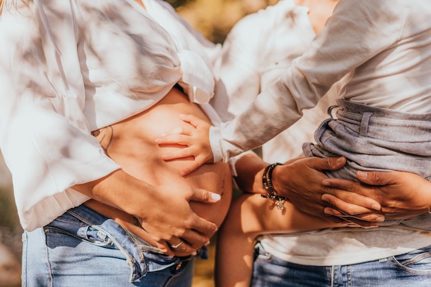 Foto die hand des mädchens berührt den bauch ihrer schwangeren mutter. lgtbi-familie