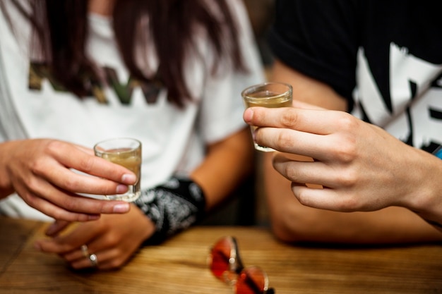 Foto die hand des paares, die tequila hält, schoss in hände