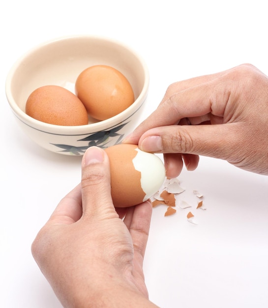 Die Hand, die die gekochte Eierschale schält